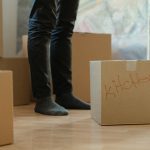 Bir dairede paketleme yapan kişiler, kutular ve ev eşyaları